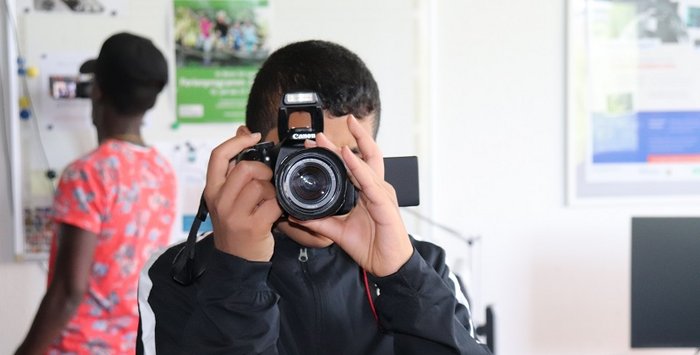 Junge fotografiert mit professioneller Kamera