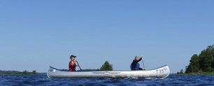 Zwei Kinder im Kanu auf einem See.