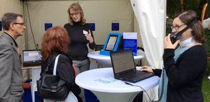 Susanne Böhmig erklärt am Stand der STIFTUNG barrierefrei kommunizieren! Besuchern unterstützende Technologien