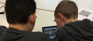 Zwei Jungen über einem Tablet.