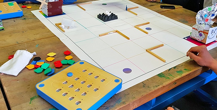 Holzroboter Cubetto auf selbstgebastelten Labyrinth aus Papier